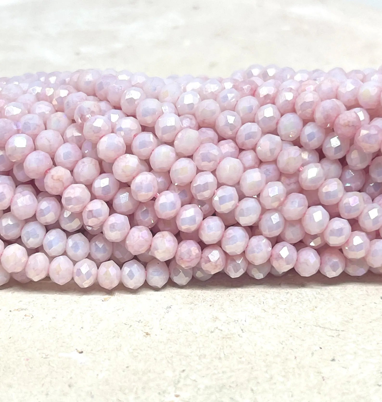 Ein Strang Glasperlen, facettiert, bedampft.
Farbe: Hellrosa mit AB Schimmer