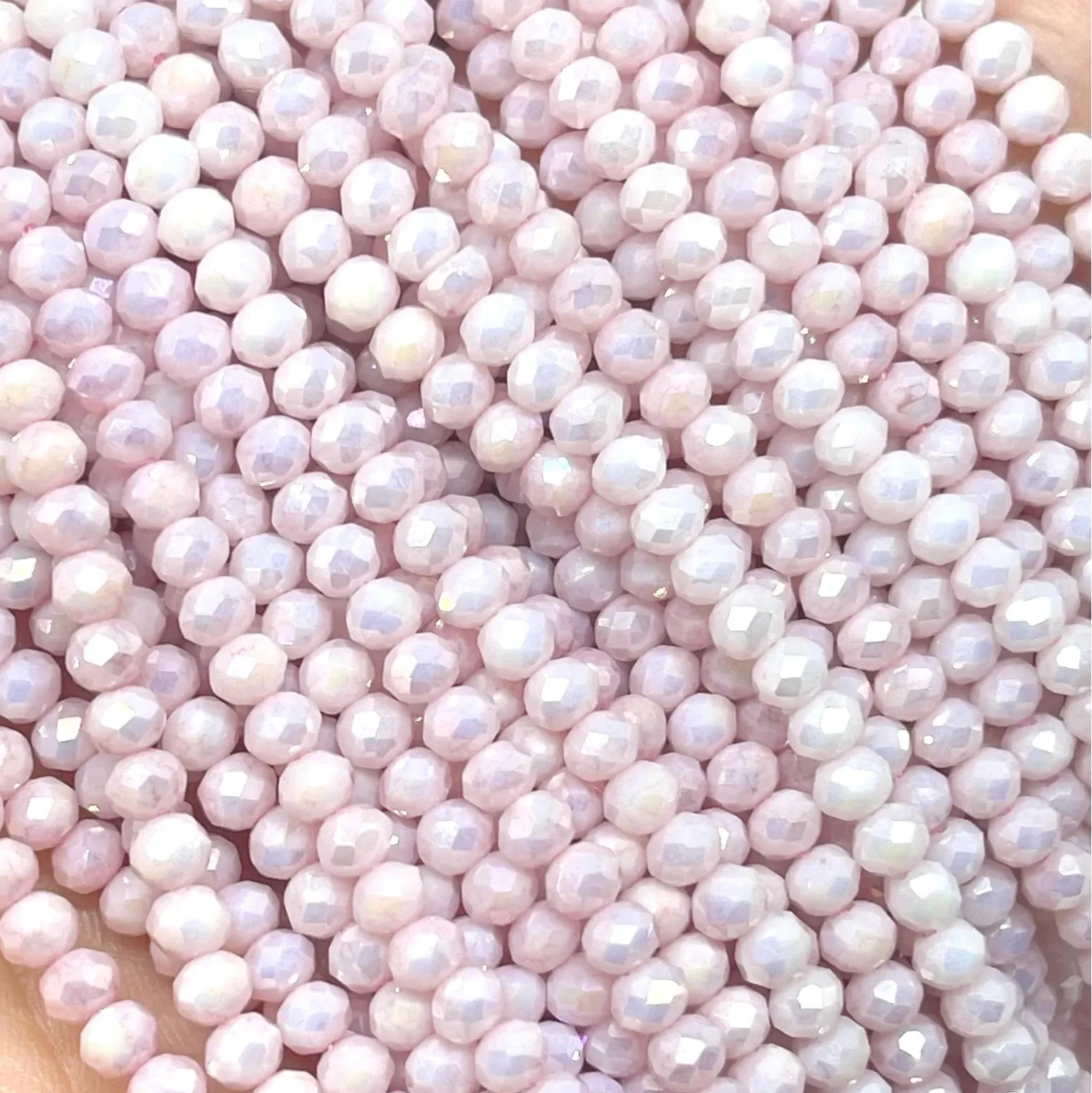 Ein Strang Glasperlen, facettiert, bedampft.
Farbe: Hellrosa mit AB Schimmer