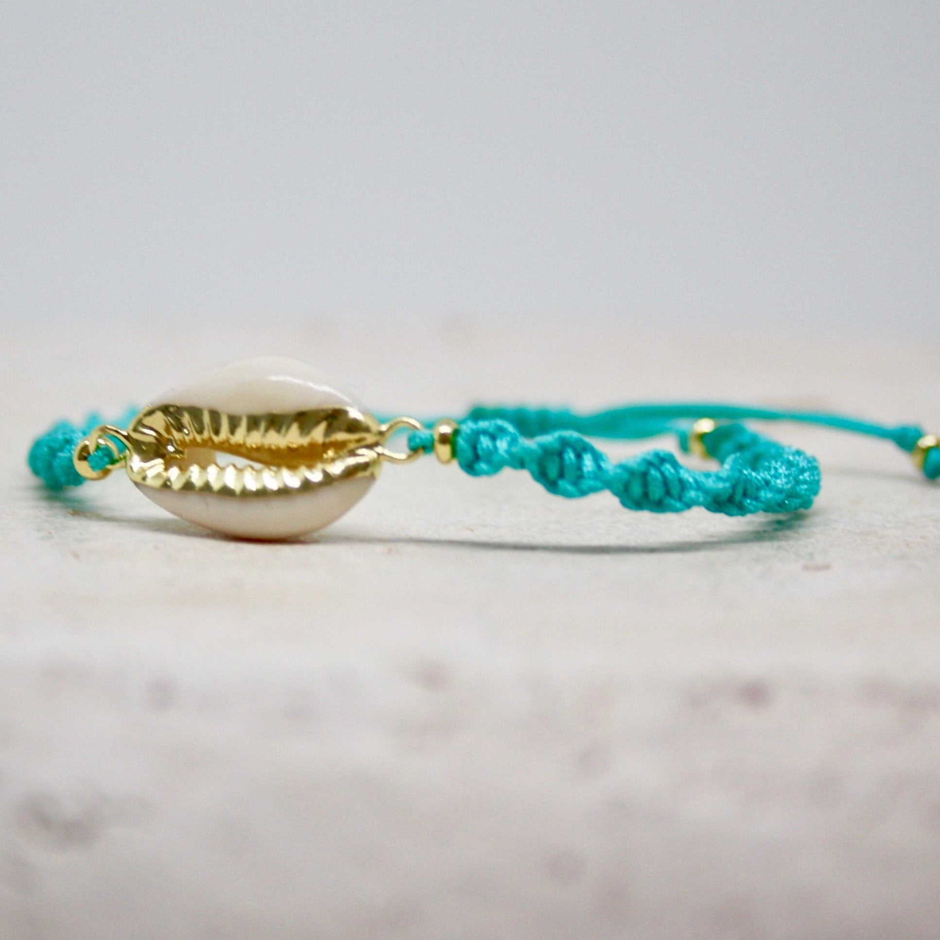 Armband mit Cauri Muschel und Fisch Anhänger