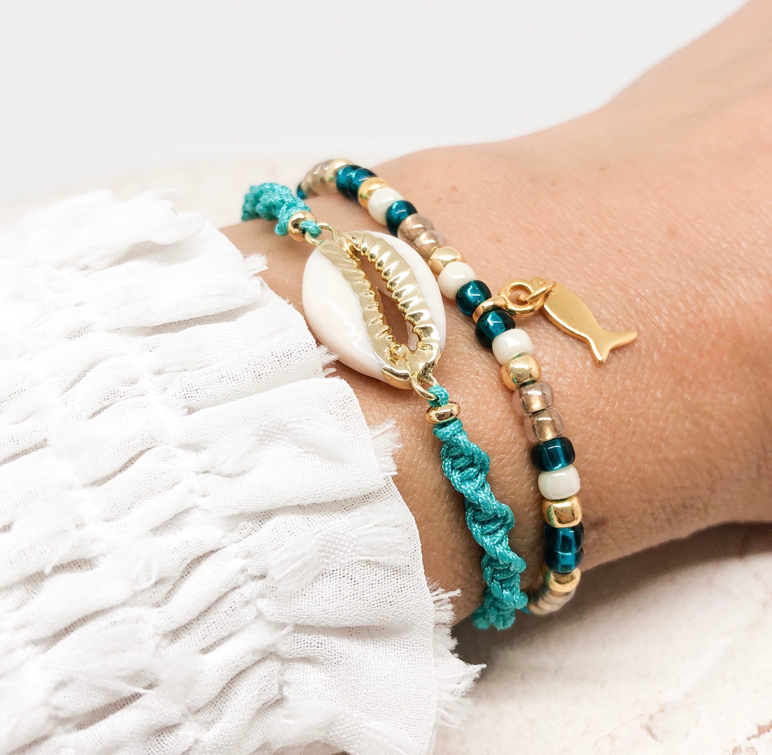 Armband mit Cauri Muschel und Fisch Anhänger