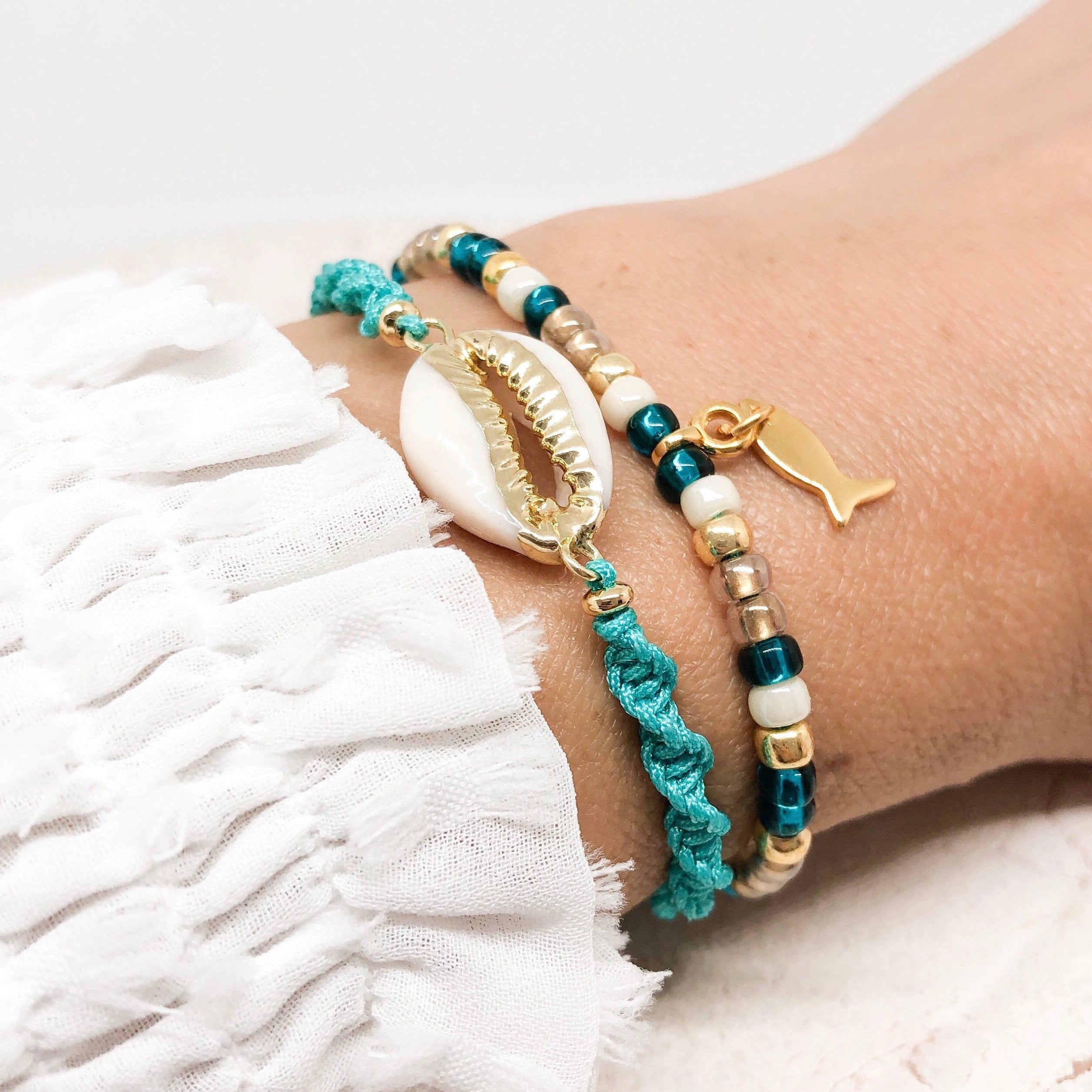 Armband mit Cauri Muschel und Fisch Anhänger