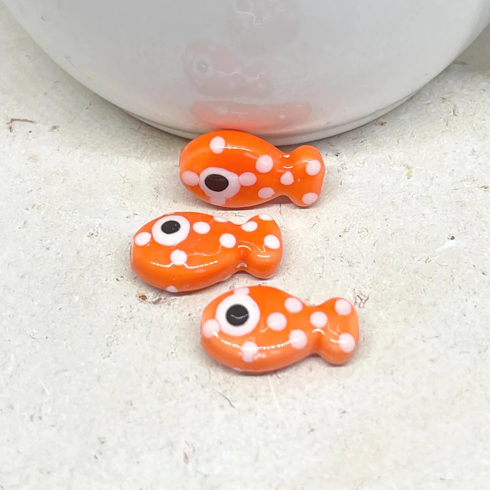 Porzellan Fisch Perle Orange mit weißen Punkten.