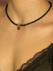 Kurze Halskette mit schwarzen Kristallperlen und einem Plättchen