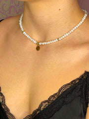 Kurze Halskette mit Süßwasserperlen und einem Plättchen